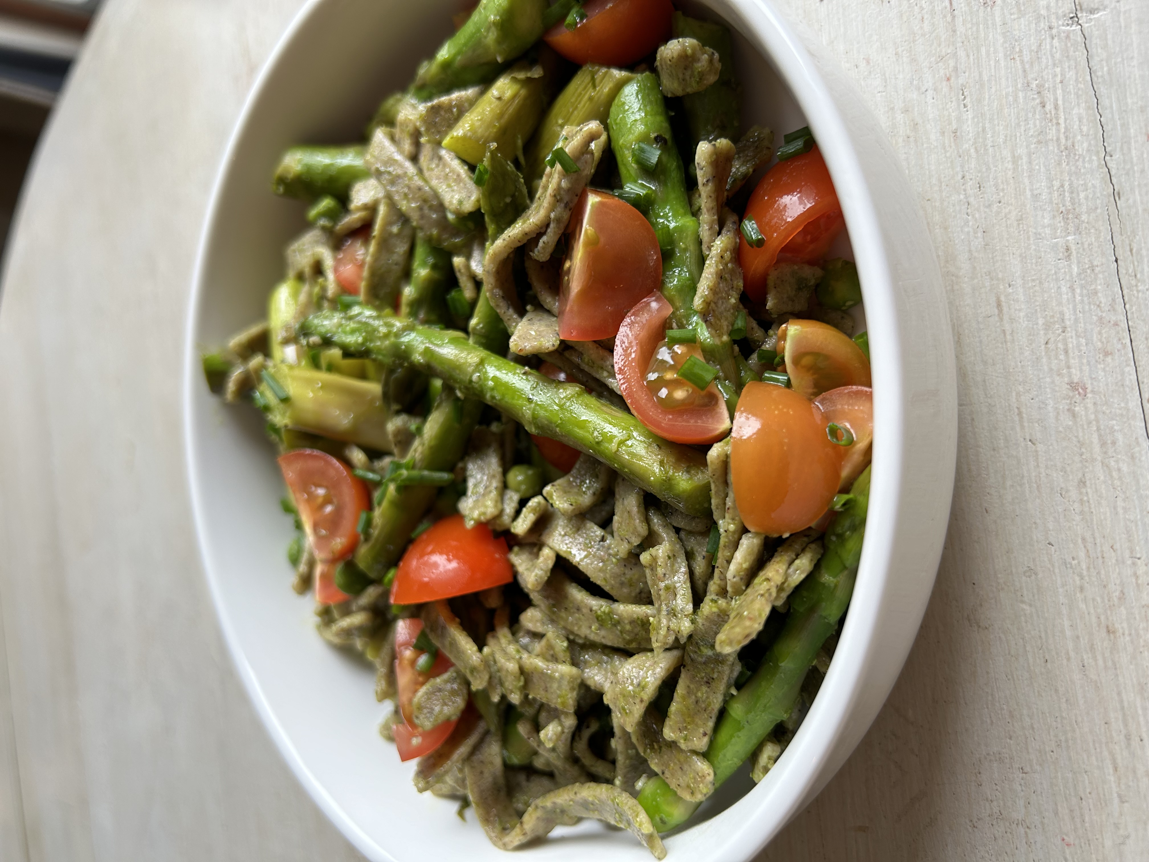 Pâtes fraiches sans gluten au sarrasin avec des asperges, des petits pois, du pesto d’ail des ours et des tomates cerises 